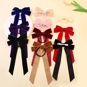 Colorful velvet hair bows with long tails set on elegant light beige background