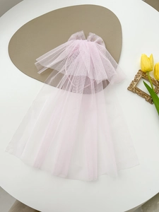 Detail of pink multi-layered tulle headpiece with gold star sequins and bow decoration