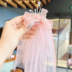 Détail d'un nœud rose avec couronne de strass argentés et long voile en tulle