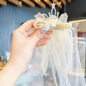 Détails d'une pince à cheveux couronne étoilée avec voile en tulle fluide pour enfants