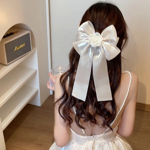 Elegant silk ribbon hair clip with camellia flower and pearls worn by a model