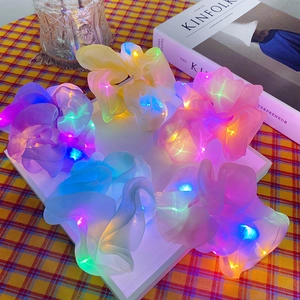 Chouchous en organza à LED lumineuses multicolores sur une table basse élégante