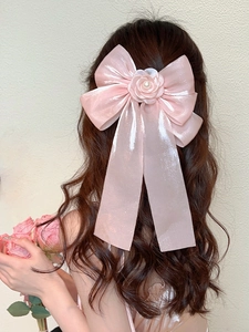 Close-up of pink oversized bow hair clip with 3D rose flower and pearl detail