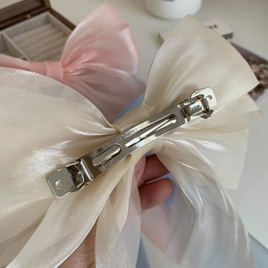 Détail de la pince en métal sur un nœud en organza de soie avec gravure Picked