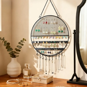 Circular wall-mounted black jewelry organizer with earring mesh and necklace hooks