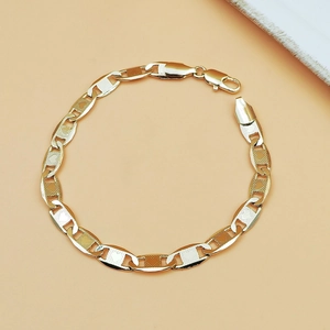 Detail of gold chain anklet featuring textured hollow links and a lobster clasp closure