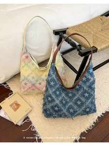 Detail shot of vintage denim tote bags with star patterns and brown leather straps