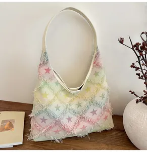 Detail of canvas hobo bag featuring colorful gradient star patterns and frayed edges