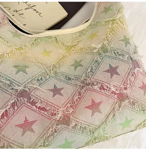 Close-up of denim tote bag showing colorful square patterns and fringed star details