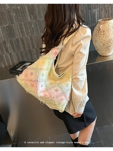 Detail of vintage beige tote bag with colorful stars and frayed tassel edges for women