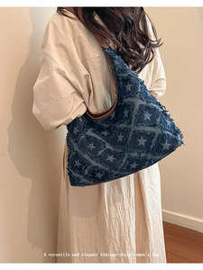 Lifestyle view of vintage denim tote bag featuring star patterns and frayed edges