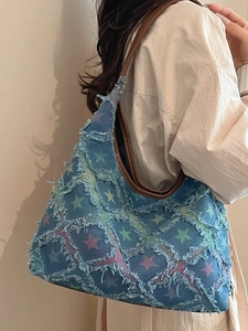 Retro denim tote bag with colorful stars and faux leather straps on a model
