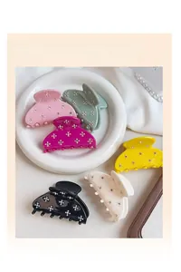 Détail de pinces à cheveux en acétate coloré avec motifs de fleurs en strass.