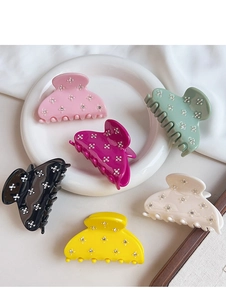 Close-up of colorful acetate hair claw clips with elegant rhinestone flower patterns