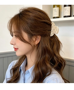 Elegant cream hair claw clip with rhinestone details shown on long wavy hair.