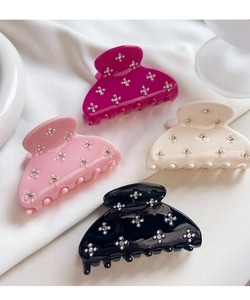 Detailed macro view of candy-colored acetate hair claw clips with rhinestone flower patterns.