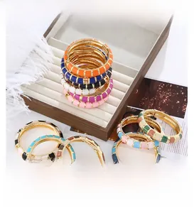 Detail of colorful bohemian enamel bangles with vibrant drip oil patterns in a jewelry box