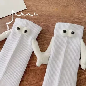 Détail de chaussettes mi-mollet blanches avec mains 3D et yeux magnétiques