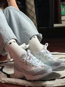 Gros plan de chaussettes blanches magnétiques avec ailes 3D et yeux brodés sur baskets