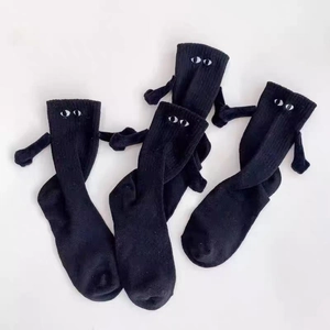 Détail de chaussettes magnétiques avec mains 3D et yeux de dessin animé en coton noir