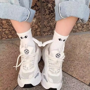 Gros plan de chaussettes aimantées avec mains 3D et baskets blanches à plateforme