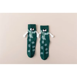 Gros plan de chaussettes magnétiques vertes avec yeux 3D et mains tenant ensemble