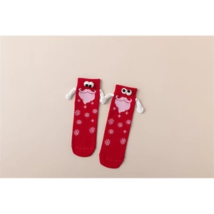Détail des chaussettes de Noël rouges aimantées avec mains 3D et motifs de flocons de neige