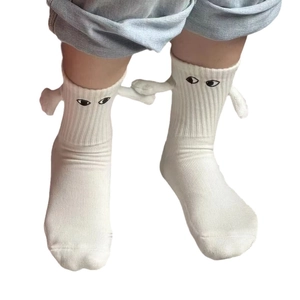 Chaussettes blanches magnétiques tenant les mains avec yeux de dessin animé