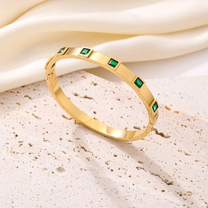 Gold plated titanium steel bangle featuring square green zircon stones in a polished finish