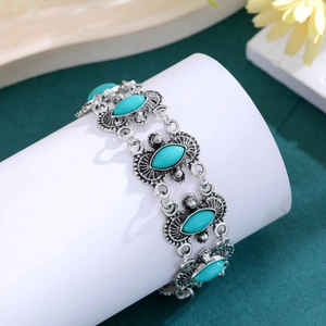 Close-up of vintage bohemian bracelet with turquoise stones and antique silver carving