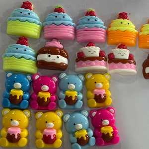 Makro-Detail von bunten Harz-Bären und Cupcake-Anhängern für DIY-Handyhüllen-Handwerk