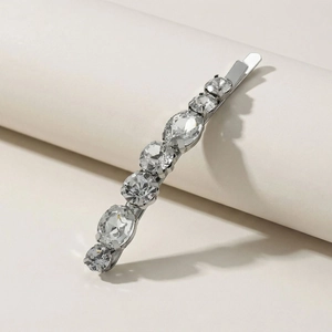 Elegant silver hairpin with seven clear sparkling crystals on a minimalist white stand