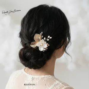 Close-up of handmade bridal hair comb with pearls and rhinestones on a gold wire