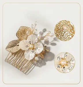 Detailed close-up of handmade shell flower hair comb with pearls and gold alloy leaves