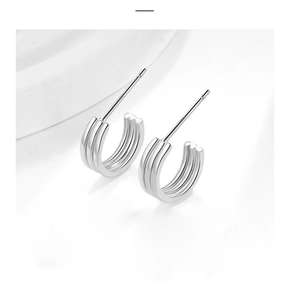Macro shot of S925 sterling silver triple-line hoop earrings with polished finish