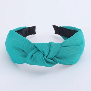 Detail of bright cyan knotted headband showing fine twill fabric texture and anti-slip lining