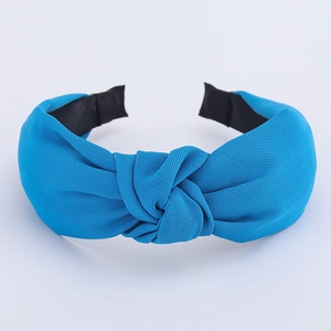 Detail view of blue knotted headband with fine ribbed fabric texture and non-slip inner edge