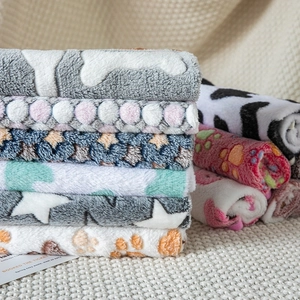 Soft fleece pet blankets with paw and bone prints in multiple colors for cats and dogs