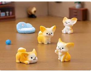 Miniature resin fennec fox figurines with blue sofa and ball accessories on wood
