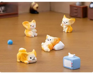 Detailed view of four resin fox miniatures and a small blue TV set on wood