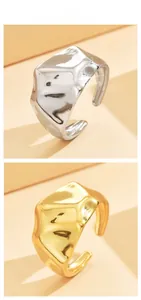 Detail of irregular textured chunky metal rings in polished gold and silver finishes