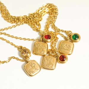 Detailed view of vintage 18K gold plated zodiac pendant necklaces with colorful gemstones