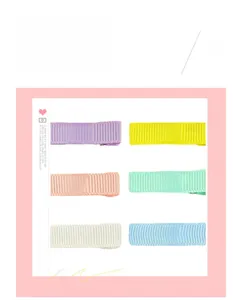 Detail view of colorful ribbed grosgrain ribbon wrapped hair clips in pastel tones