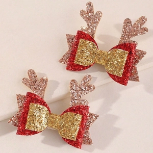 Détail de barrettes de Noël avec nœuds rouges scintillants et bois de renne or rose