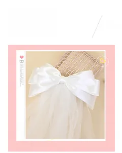 Détail du nœud papillon blanc avec ruban en satin et tulle multicouche pour mariage