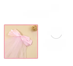 Détail d'une pince à cheveux nœud rose avec tissu satiné et rubans en tulle légers