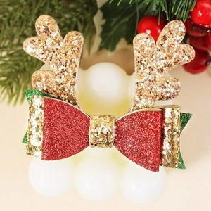 Détail de la barrette de Noël avec bois dorés scintillants et un joli nœud rouge