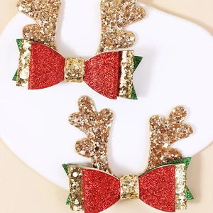 Détail de pinces à cheveux bois de renne de Noël à paillettes avec des nœuds rouges