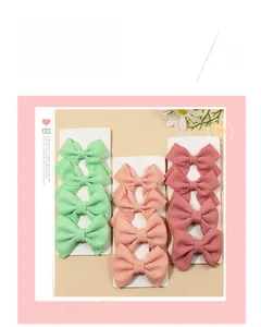 Close-up of waffle texture fabric hair bows in green and pink on a display card