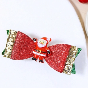 Gros plan d'une pince à cheveux de Noël à paillettes avec figurine de Père Noël